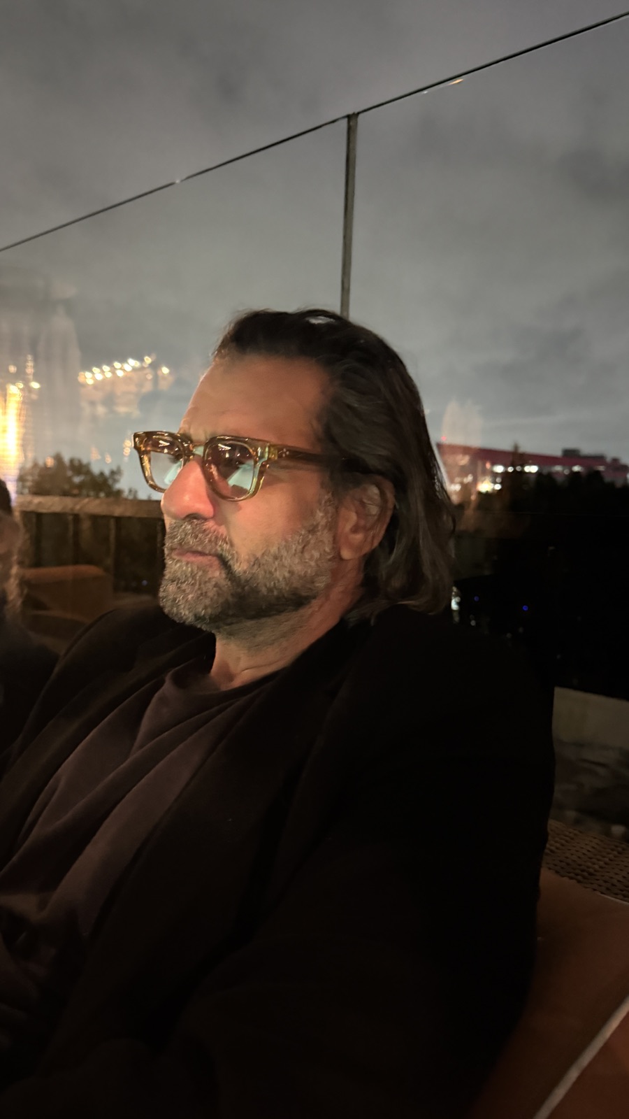 A man on a rooftop at dusk wearing Frame Style 1